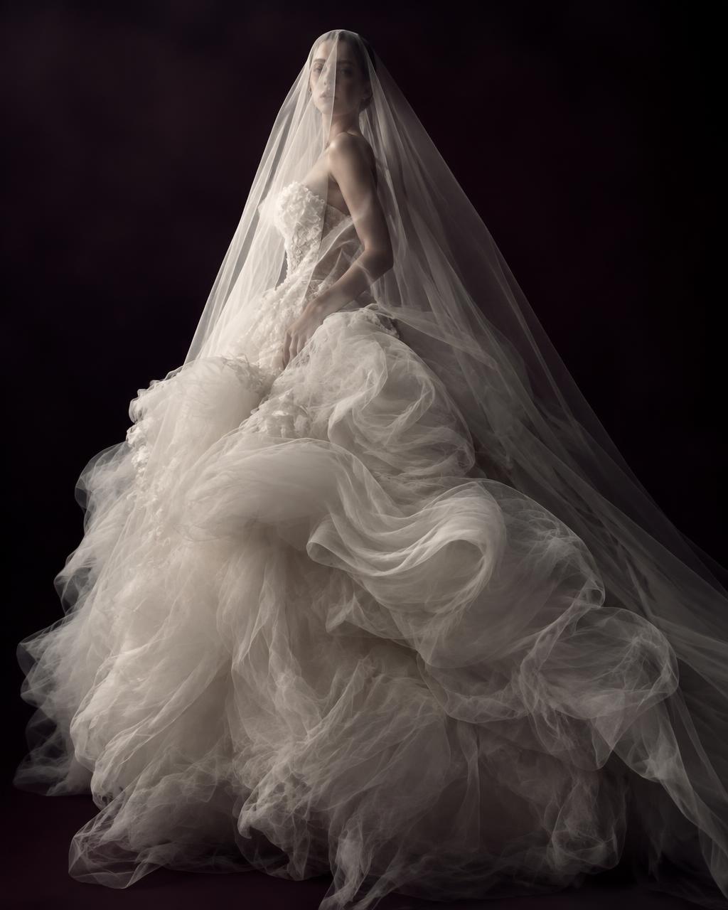 Voluminous couture-white bridal gown with a tulle skirt in soft studio light
