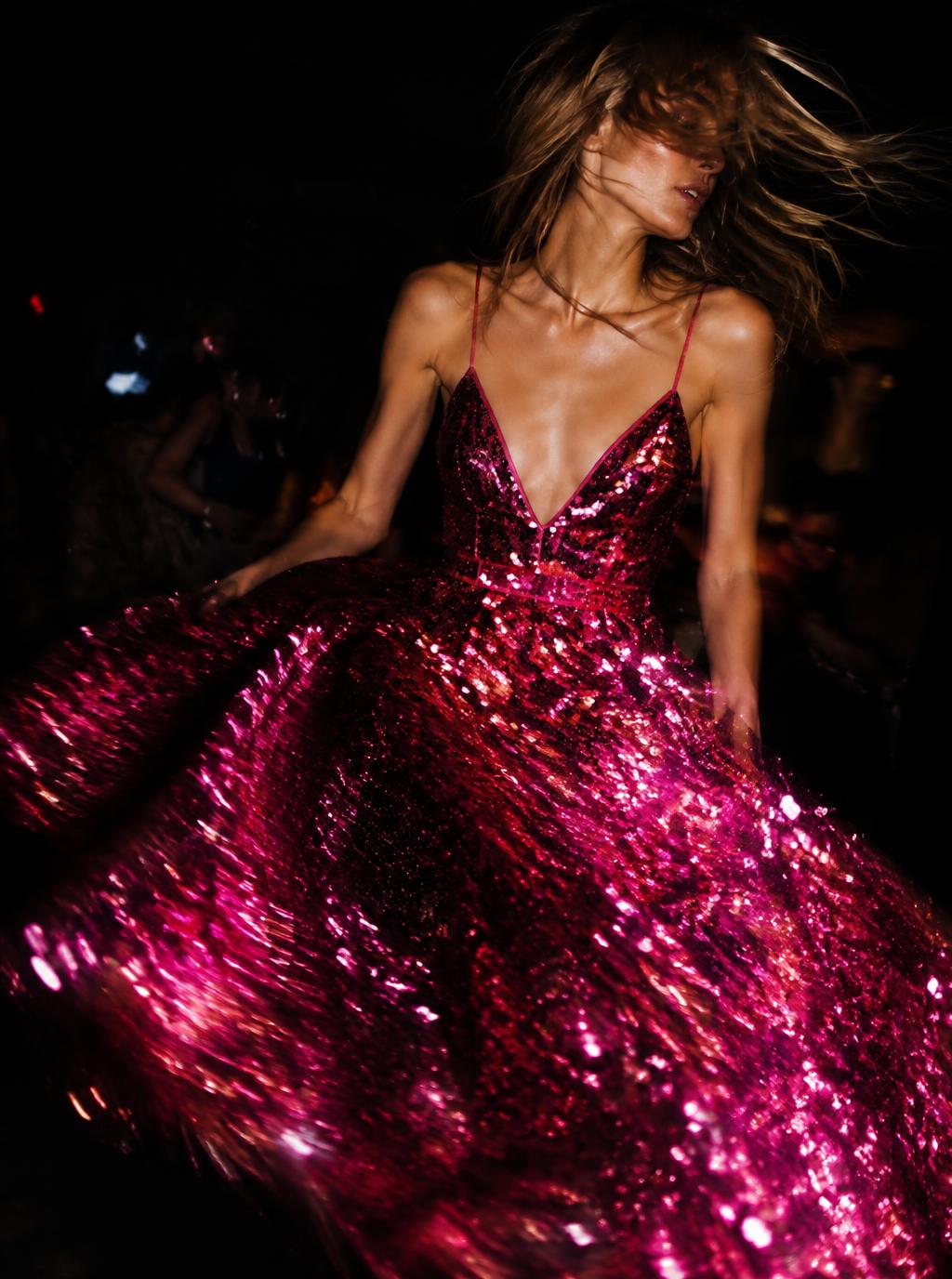 Glittering fuchsia gala dress mid-turn with a hint of motion blur